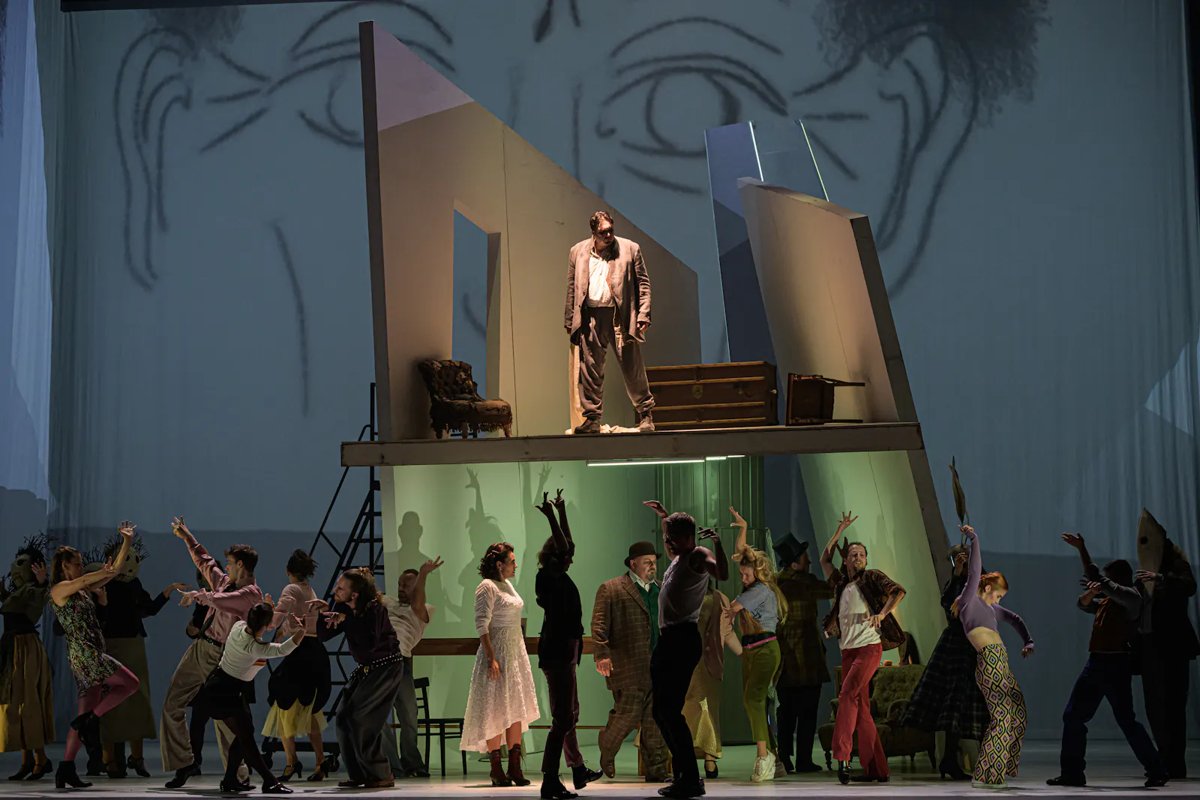 Sweeney Todd ve Státní opeře — Adam Plachetka jako Sweeney Todd na vyvýšené scéně, pod ním Sbor Státní opery